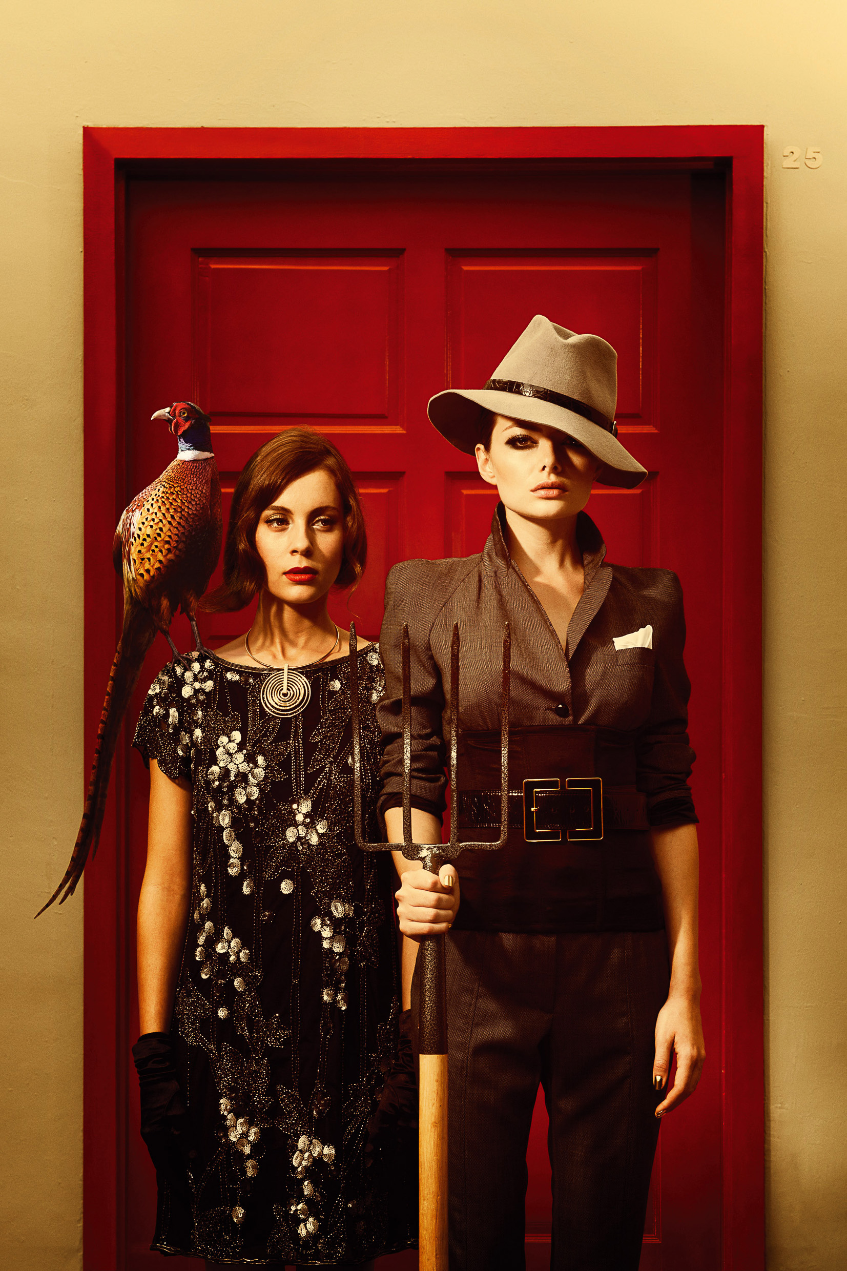2 female models holding a pitch fork with a pheasant